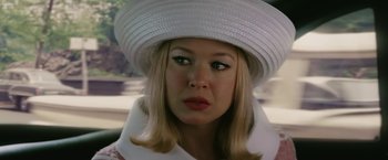 Movie still from “Down with Love” (2003), directed by Peyton Reed – A woman wearing a white hat and a white coat; Close Up shot, Over the shoulder angle