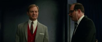 Movie still from “Down with Love” (2003), directed by Peyton Reed – A man in a suit and tie standing next to another man in a suit; Medium shot, Low angle