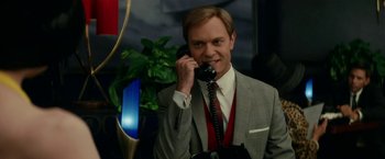 Movie still from “Down with Love” (2003), directed by Peyton Reed – A man in a gray suit talking on a phone; Medium shot, Low angle