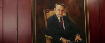 Movie still from “Down with Love” (2003), directed by Peyton Reed – A painting of an older man wearing a suit and tie sitting in a chair; Medium shot, High angle