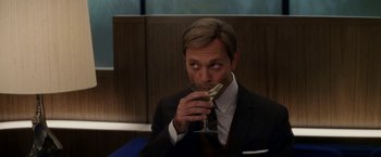 Movie still from “Down with Love” (2003), directed by Peyton Reed – A man in a suit and tie drinking a glass of wine; Close Up shot, High angle