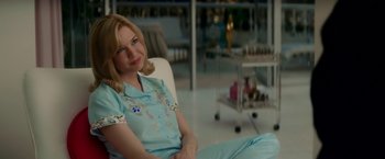 Movie still from “Down with Love” (2003), directed by Peyton Reed – A woman sitting on a chair in a room; Medium shot, Over the shoulder angle