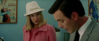 Movie still from “Down with Love” (2003), directed by Peyton Reed – A woman wearing a pink coat and a white hat looking at a man in a white hat; Close Up shot, Over the shoulder angle