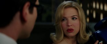 Movie still from “Down with Love” (2003), directed by Peyton Reed – A woman looking into a mirror while wearing red lipstick; Close Up shot, Over the shoulder angle