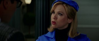 Movie still from “Down with Love” (2003), directed by Peyton Reed – A woman wearing a blue coat and a blue hat; Close Up shot, Over the shoulder angle