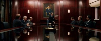 Movie still from “Down with Love” (2003), directed by Peyton Reed – Three men are sitting at a conference room table; Wide shot, Over the shoulder angle