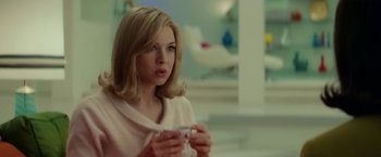 Movie still from “Down with Love” (2003), directed by Peyton Reed – A woman with blonde hair holding a cup in her hands; Medium shot, Over the shoulder angle