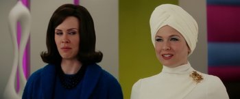 Movie still from “Down with Love” (2003), directed by Peyton Reed – Two women standing next to each other in front of a green wall; Close Up shot, Over the shoulder angle