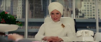 Movie still from “Down with Love” (2003), directed by Peyton Reed – A woman in a turban sitting at a desk; Close Up shot, Over the shoulder angle