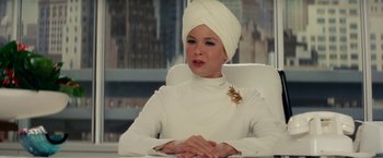 Movie still from “Down with Love” (2003), directed by Peyton Reed – A woman in a white dress sitting in a chair with her hands crossed; Close Up shot, Low angle
