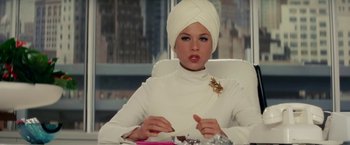 Movie still from “Down with Love” (2003), directed by Peyton Reed – A woman in a turban sitting at a table; Medium shot, Low angle