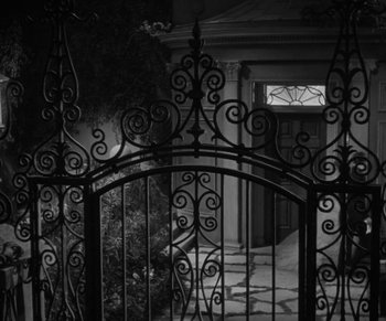 Movie still from “Dr. Jekyll and Mr. Hyde” (1931), directed by Rouben Mamoulian – An open gate with a wrought - iron fence around it; Extreme Wide shot, High angle