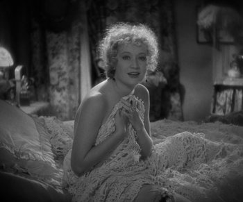 Movie still from “Dr. Jekyll and Mr. Hyde” (1931), directed by Rouben Mamoulian – A black - and - white photo of a woman sitting on a bed; Medium shot, High angle