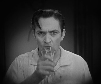 Movie still from “Dr. Jekyll and Mr. Hyde” (1931), directed by Rouben Mamoulian – A black and white photo of a man drinking a glass of water; Close Up shot, Low angle