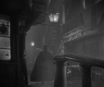 Movie still from “Dr. Jekyll and Mr. Hyde” (1931), directed by Rouben Mamoulian – A man in a black cape standing next to a lamp post; Extreme Wide shot, High angle
