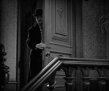 Movie still from “Dr. Jekyll and Mr. Hyde” (1931), directed by Rouben Mamoulian – A man standing in front of a door way; Medium shot, Low angle