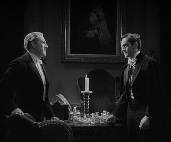 Movie still from “Dr. Jekyll and Mr. Hyde” (1931), directed by Rouben Mamoulian – Two men in suits are sitting at a dinner table; Medium shot, Over the shoulder angle