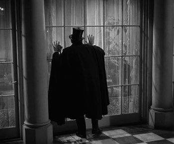Movie still from “Dr. Jekyll and Mr. Hyde” (1931), directed by Rouben Mamoulian – A man wearing a top hat and a long cape; Wide shot, Low angle
