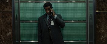 Movie still from “Don't Look Up” (2021), directed by Adam McKay – A man in a suit and tie talking on a cell phone; Medium shot, Low angle