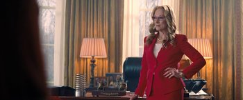 Movie still from “Don't Look Up” (2021), directed by Adam McKay – A woman in a red suit standing in front of a desk; Medium shot, Low angle