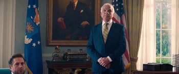 Movie still from “Don't Look Up” (2021), directed by Adam McKay – An older man standing in front of an american flag; Medium shot, Low angle