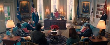 Movie still from “Don't Look Up” (2021), directed by Adam McKay – A group of people sitting around a desk in a room; Wide shot, High angle