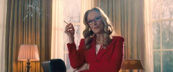Movie still from “Don't Look Up” (2021), directed by Adam McKay – A woman in a red jacket smoking a cigarette; Medium shot, Low angle