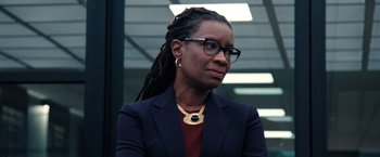 Movie still from “Don't Look Up” (2021), directed by Adam McKay – A woman wearing glasses and a suit and looking to her left; Close Up shot, Low angle
