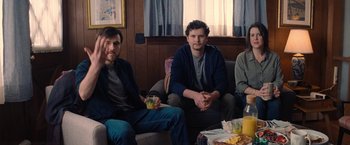 Movie still from “Don't Look Up” (2021), directed by Adam McKay – A group of people sitting in a room with food on the floor; Medium shot, Over the shoulder angle