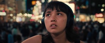 Movie still from “Don't Look Up” (2021), directed by Adam McKay – A woman wearing headphones looking up into the air; Close Up shot, Low angle