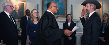 Movie still from “Don't Look Up” (2021), directed by Adam McKay – A man wearing a robe and holding a sheet of paper in front of two other people; Medium shot, Low angle