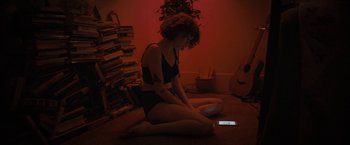 Movie still from “Don't Look Up” (2021), directed by Adam McKay – A woman sitting on the floor looking at a cell phone; Medium shot, High angle