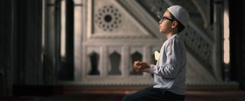 Movie still from “Don't Look Up” (2021), directed by Adam McKay – A young man sitting on the ground in front of a building; Medium shot, High angle