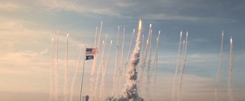 Movie still from “Don't Look Up” (2021), directed by Adam McKay – An american flag flying in front of a bunch of rockets; Extreme Wide shot, Low angle