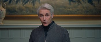 Movie still from “Don't Look Up” (2021), directed by Adam McKay – An older man in a black jacket looks at the camera; Medium shot, Over the shoulder angle