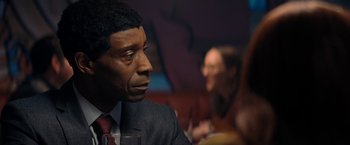 Movie still from “Don't Look Up” (2021), directed by Adam McKay – A person sitting at a table with a glass of wine; Close Up shot, Over the shoulder angle