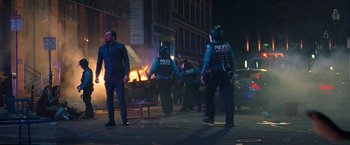 Movie still from “Don't Look Up” (2021), directed by Adam McKay – A group of police officers standing on the side of the street; Wide shot, Low angle