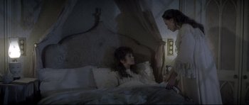Movie still from “Dracula” (1979), directed by John Badham – Two women are sitting on a bed in the dark; Medium shot, High angle