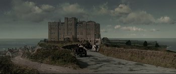 Movie still from “Dracula” (1979), directed by John Badham – A group of people walking down a dirt road near a castle; Extreme Wide shot, Low angle