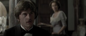 Movie still from “Dracula” (1979), directed by John Badham – A man and a woman in formal attire in front of a table; Close Up shot, Over the shoulder angle