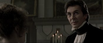 Movie still from “Dracula” (1979), directed by John Badham – A man in a black shirt and a fireplace; Close Up shot, Over the shoulder angle