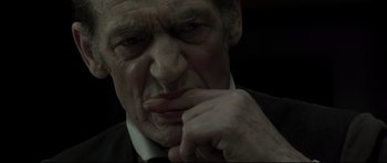 Movie still from “Dracula” (1979), directed by John Badham – An older man with a black suit and a white shirt; Close Up shot, High angle