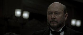 Movie still from “Dracula” (1979), directed by John Badham – An older man in a tuxedo looking at the camera; Close Up shot, Low angle