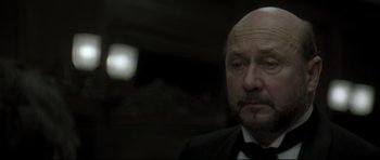 Movie still from “Dracula” (1979), directed by John Badham – An older man wearing a suit and a tie; Close Up shot, Low angle