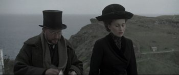 Movie still from “Dracula” (1979), directed by John Badham – A man and a woman wearing hats standing next to each other; Medium shot, Low angle