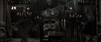 Movie still from “Dracula” (1979), directed by John Badham – Many candles lit in the dark room; Wide shot, High angle