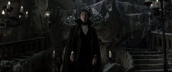 Movie still from “Dracula” (1979), directed by John Badham – A man wearing a black cape and a black cape; Medium shot, Low angle