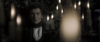 Movie still from “Dracula” (1979), directed by John Badham – A man wearing a black and white shirt and a white shirt; Medium shot, Over the shoulder angle