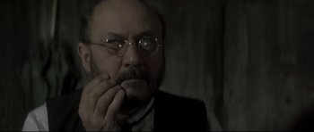 Movie still from “Dracula” (1979), directed by John Badham – A man with a beard and glasses is looking at the camera; Close Up shot, Over the shoulder angle