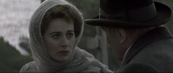 Movie still from “Dracula” (1979), directed by John Badham – A woman wearing a scarf and a hat looking at a man in a hat; Close Up shot, Over the shoulder angle